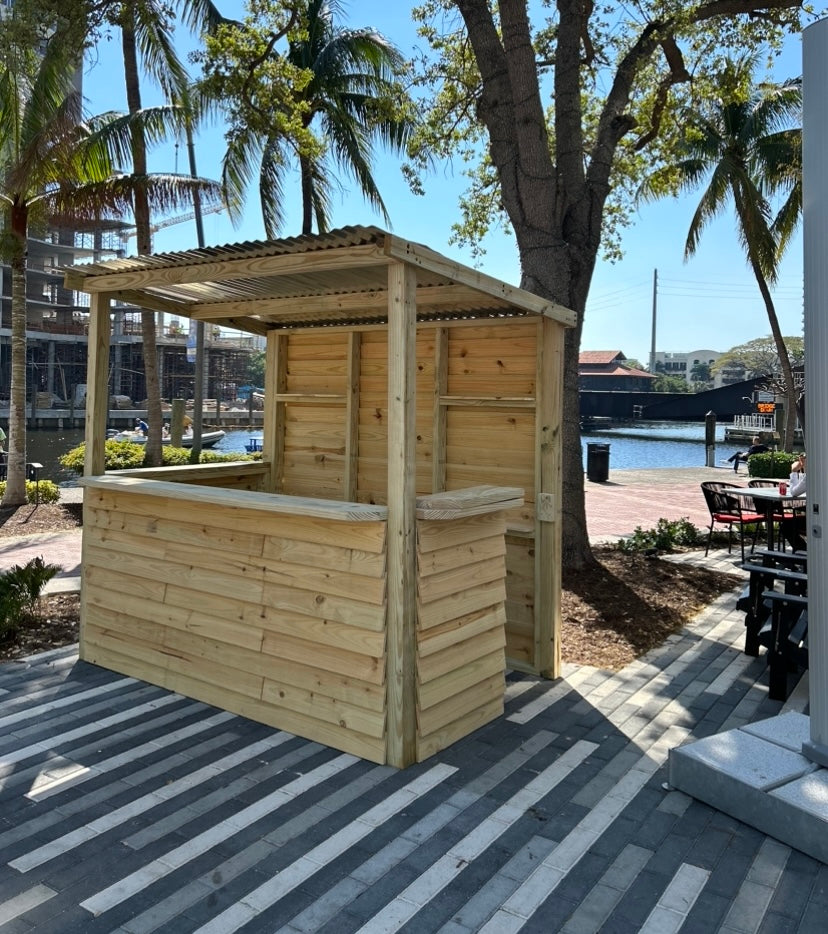 BuildABar wood bar beside palm trees and the waterfront
